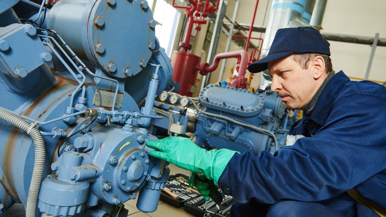 Technician replacing spare parts on industrial hydraulic machine
